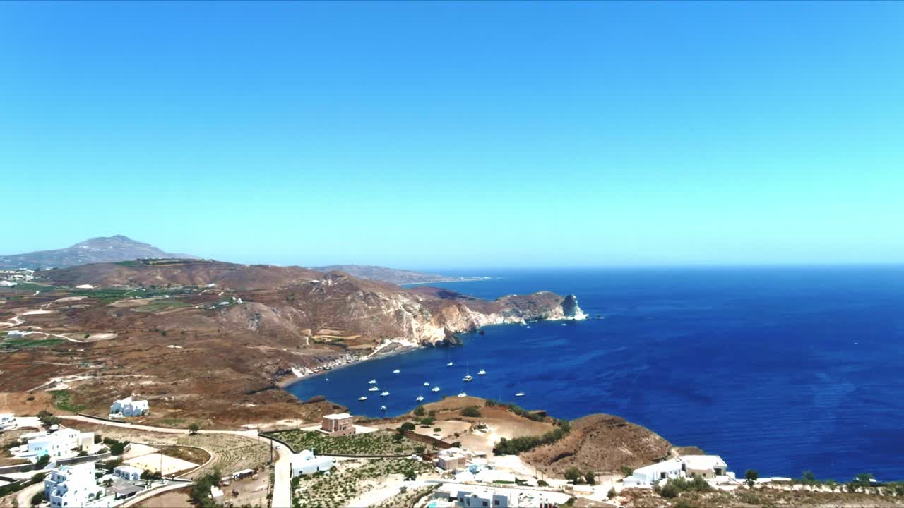 vista aérea 4k azul del mar y el cielo del pueblo de akra mavro vouno con veleros atracados en santorini grecia