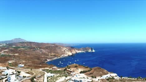 aerial 4k blue sea and sky top view of village of akra mavro vouno with sailboats docked in santorini greece