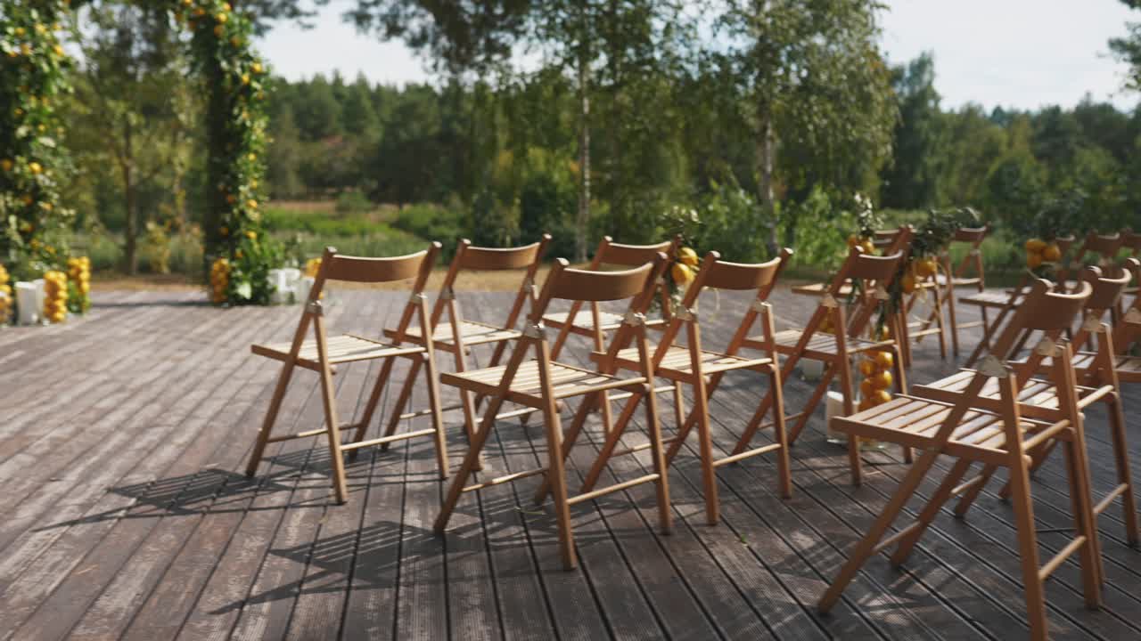 레몬 아치 와 나무 의자 를 가진 야외 결혼식