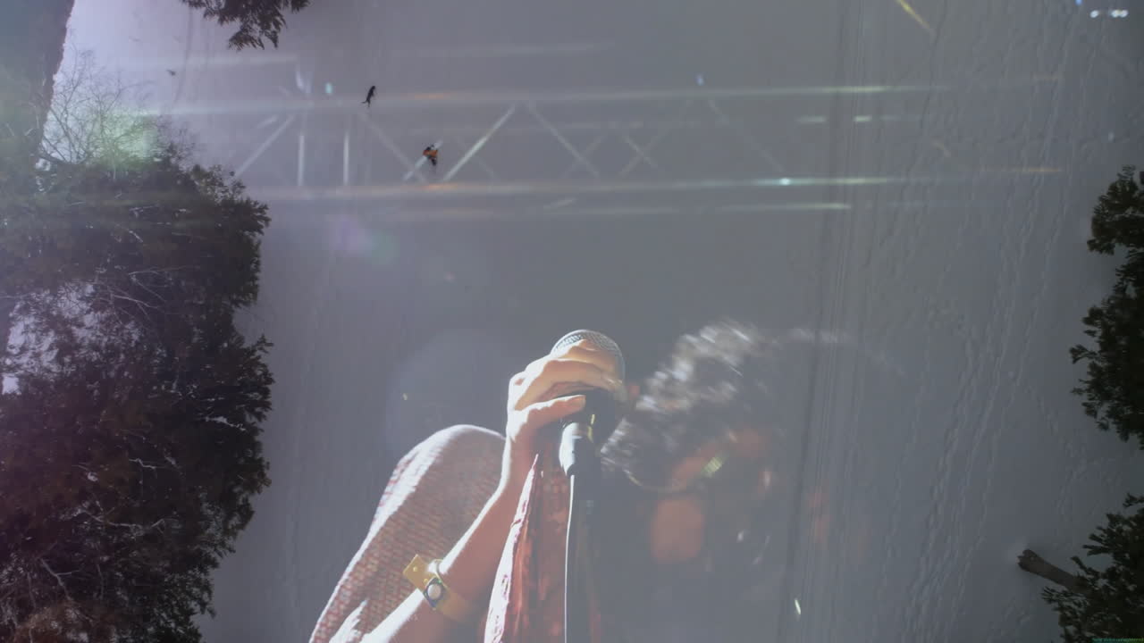 female singer gripping wired mic beside sunlit tree reflections, with floating animated music notes