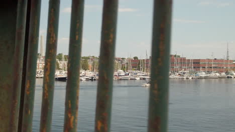 Boats-docked-in-harbor-through-railing