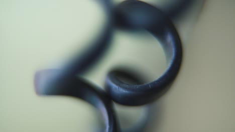 macro shot of a telephone spiral wire, black old phone cable, tilt up crane movement, 120 fps, slow motion, full hd