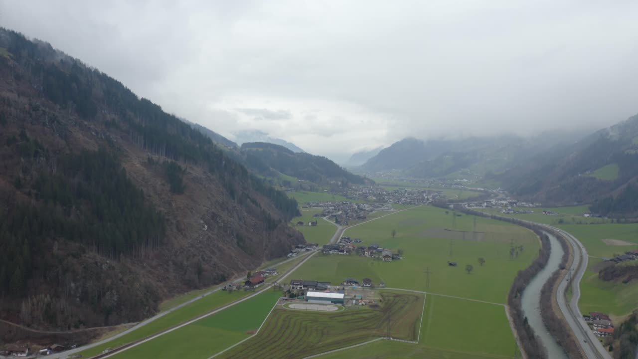 An aerial drone capture showcasing the dramatic, moody landscape of Zillertal in Tyrol with sweeping mountain vistas.