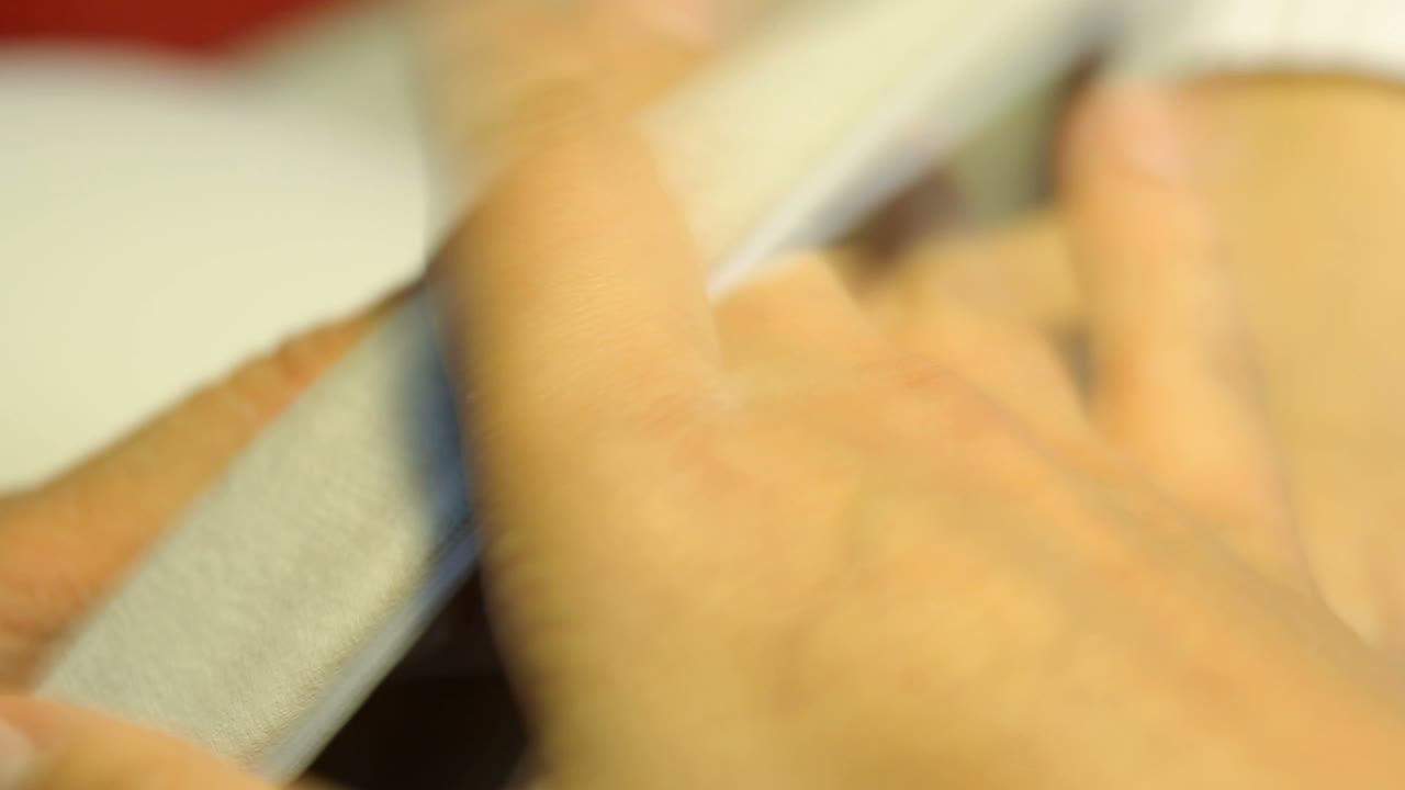 Master processes a manicure in the beauty salon