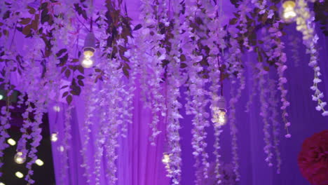 an elegant wedding reception setup featuring purple floral decor and dreamy lighting. slow motion.