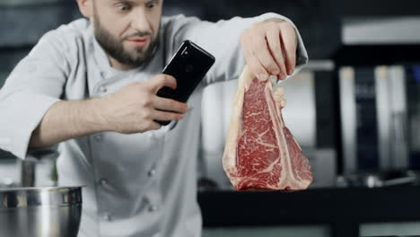 Koch-Macht-Fleischfoto-Mit-Mobiltelefon.-Männlicher-Koch,-Der-Ein-Steak-Fotografiert.