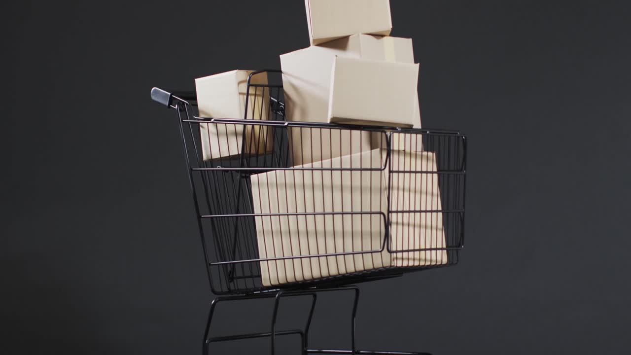 video de un carrito de compras y cajas con espacio de copia sobre un fondo gris