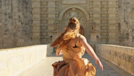 fashion model is running towards a mdina castle