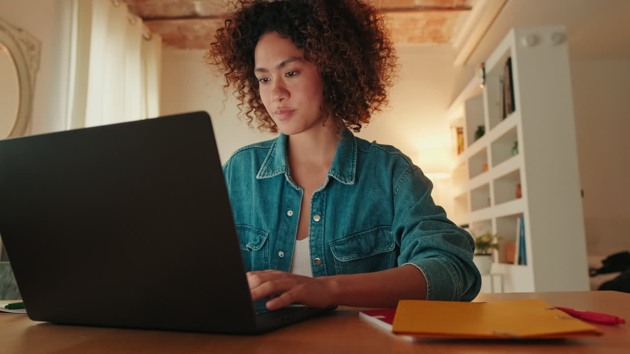 Young Woman with Curly Hair Working on Laptop at Home