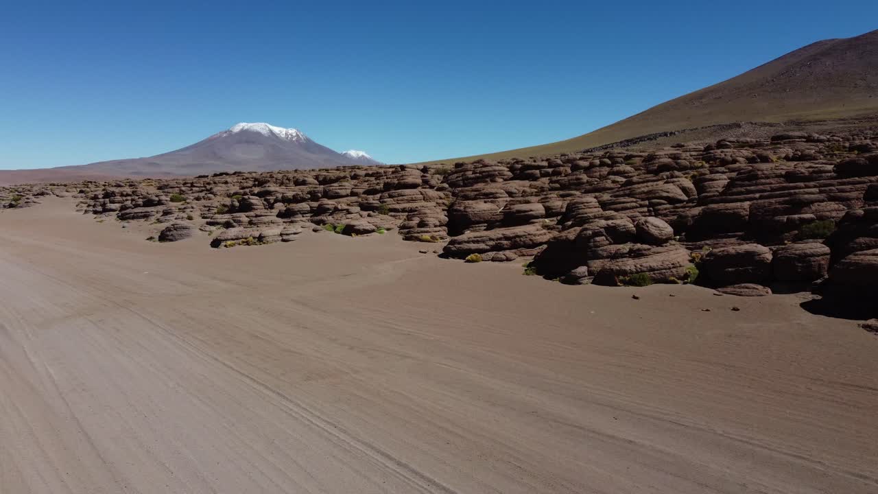 aerial sigue las huellas de vehículos en la arena del desierto, alto altiplano boliviano