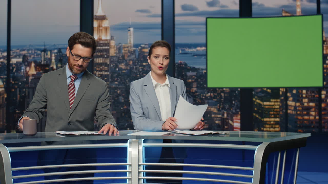 커플 뉴스 리더가 멀티미디어 채널 클로즈업에서 그린 스크린 뉴스를 보도하고 있습니다.