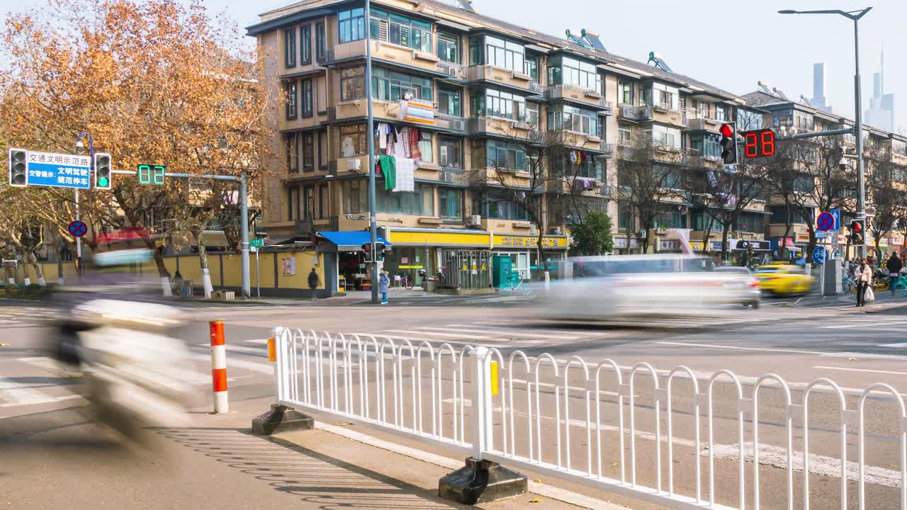 4k Timelapse video and footage of people and vehicles on a Chinese downtown city street or road close to a traffic light and apartments during daytime with bright blue skies on a sunny day panning out