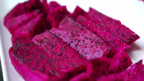 Slow-pan-up-of-red-dragon-fruit-sitting-on-white-plate-Red-and-white-dragonfruit-Red-Dragon-Fruit-Slices-and-Cultivating-Exotic-Plants-pitaya