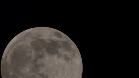 the full moon passes through the night sky