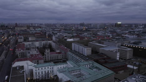 Forwards-fly-above-city-at-dusk.-Blocks-of-buildings-in-urban-neighbourhood.-Overcast-sky.-Berlin,-Germany