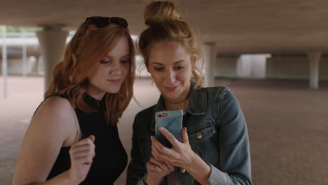 dos hermosas mujeres jóvenes usando un teléfono inteligente posando para una foto selfie haciendo caras alegres y divertidas