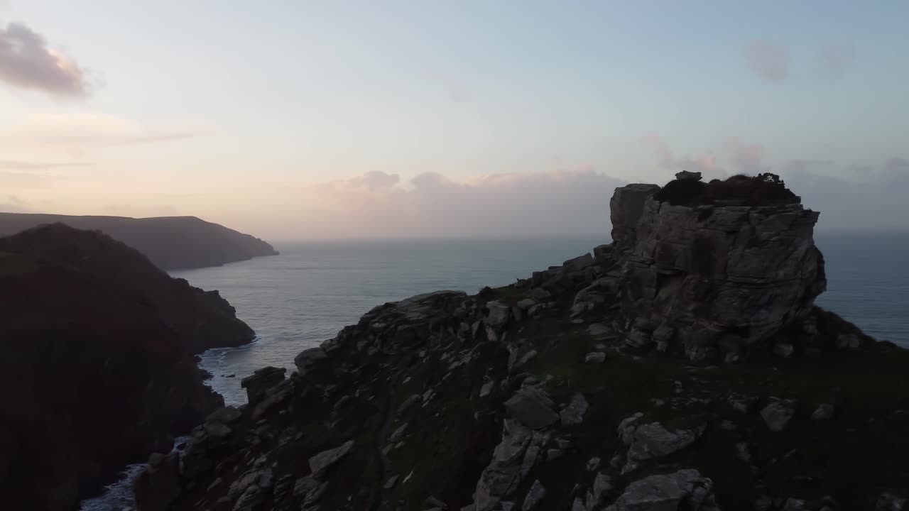 hermoso dron aéreo panorámico disparado al atardecer con rocas en lo alto de un acantilado y una espectacular costa y mar en el valle de las rocas uk 4k