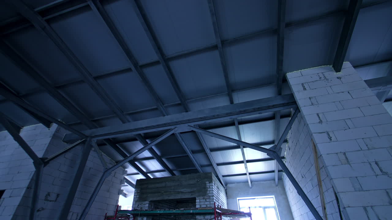 Newly constructed roof in the building. Low angle view. Interior of the premise with white brick walls.