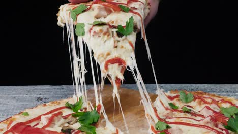 mano sosteniendo una rebanada de pizza con queso derretido