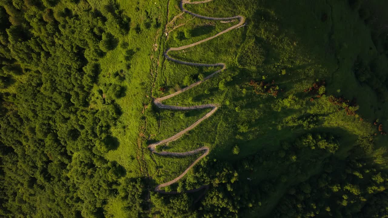 Ancient fort in Italy with winding pathways, green hills, and scenic landscapes