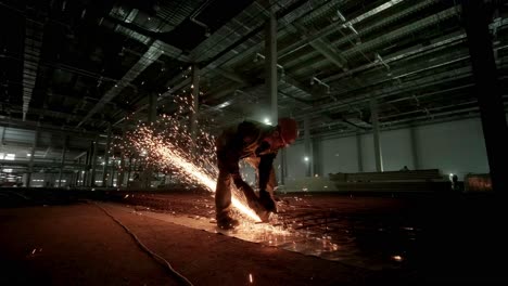 industrial professional worker is cutting metal rebar with a circular saw. construction of a factory, hangar