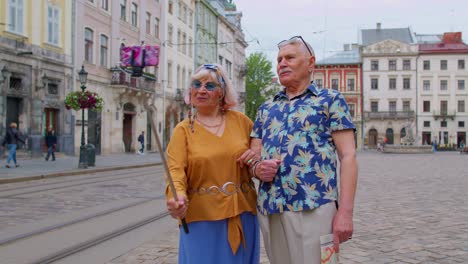 Elderly-stylish-blogger-tourists-man-woman-taking-selfie-photo,-making-video-call-on-mobile-phone