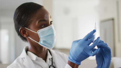 Doctora-Afroamericana-Con-Mascarilla-Preparando-La-Vacuna-Covid-Para-El-Paciente