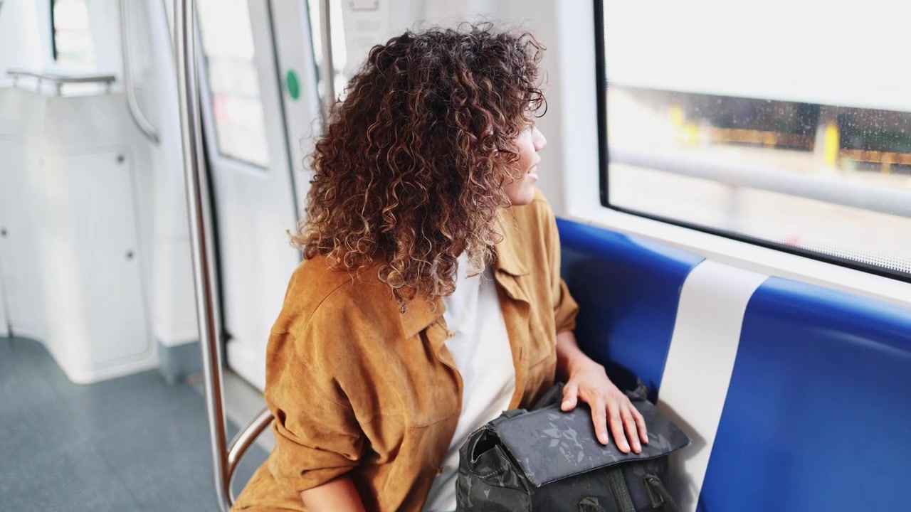 Happy Young Woman Looking Out Train Window While Commuting