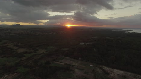 Flying-over-green-mainland-in-Mauritius-at-sunset