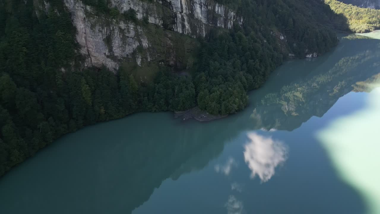 volando sopra un'area d'ombra che sta proiettando una montagna piena di alberi e colline rocciose molto chiaro riflesso delle nuvole nell'acqua come un effetto specchio giungla luogo abbandonato dove nessuno vive estate