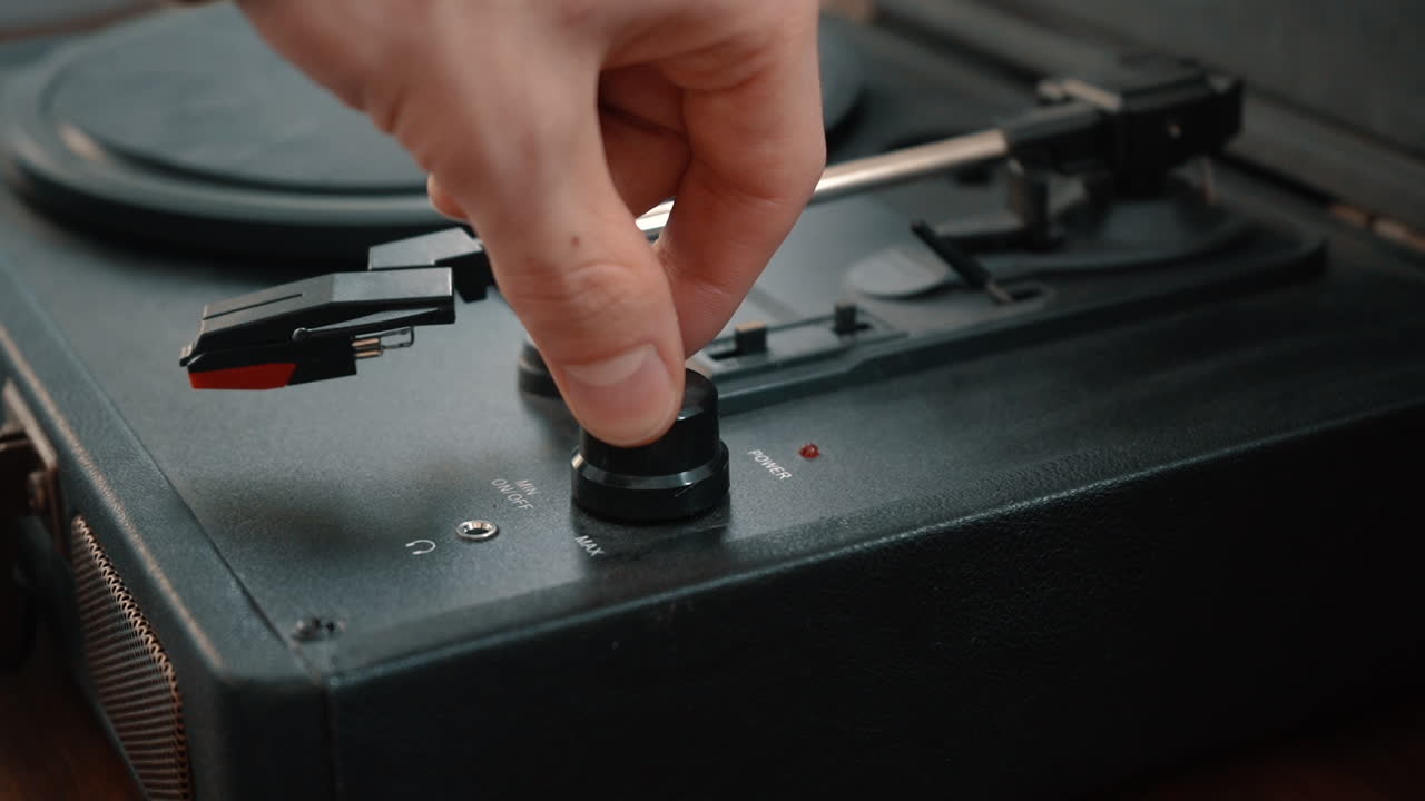 A hand turns on a turntable.