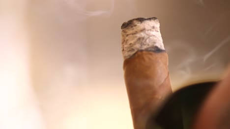 extreme close up of a brown cigar being smoked in the caribbean