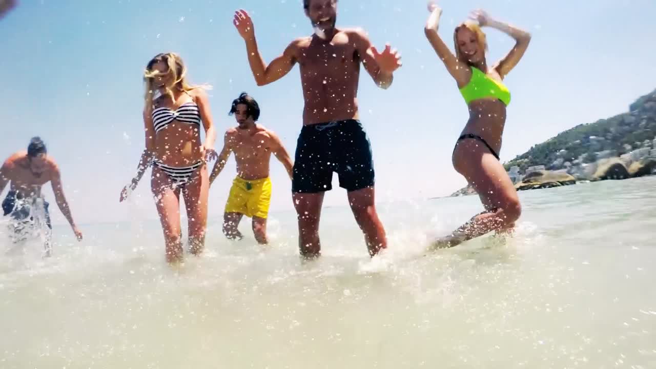 Group of friends dancing in sea
