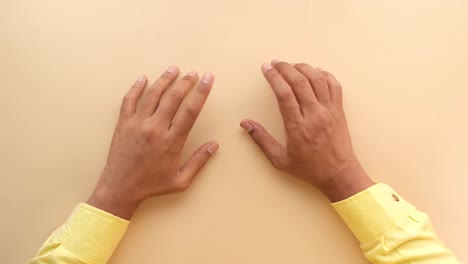 manos extendidas sobre un fondo beige