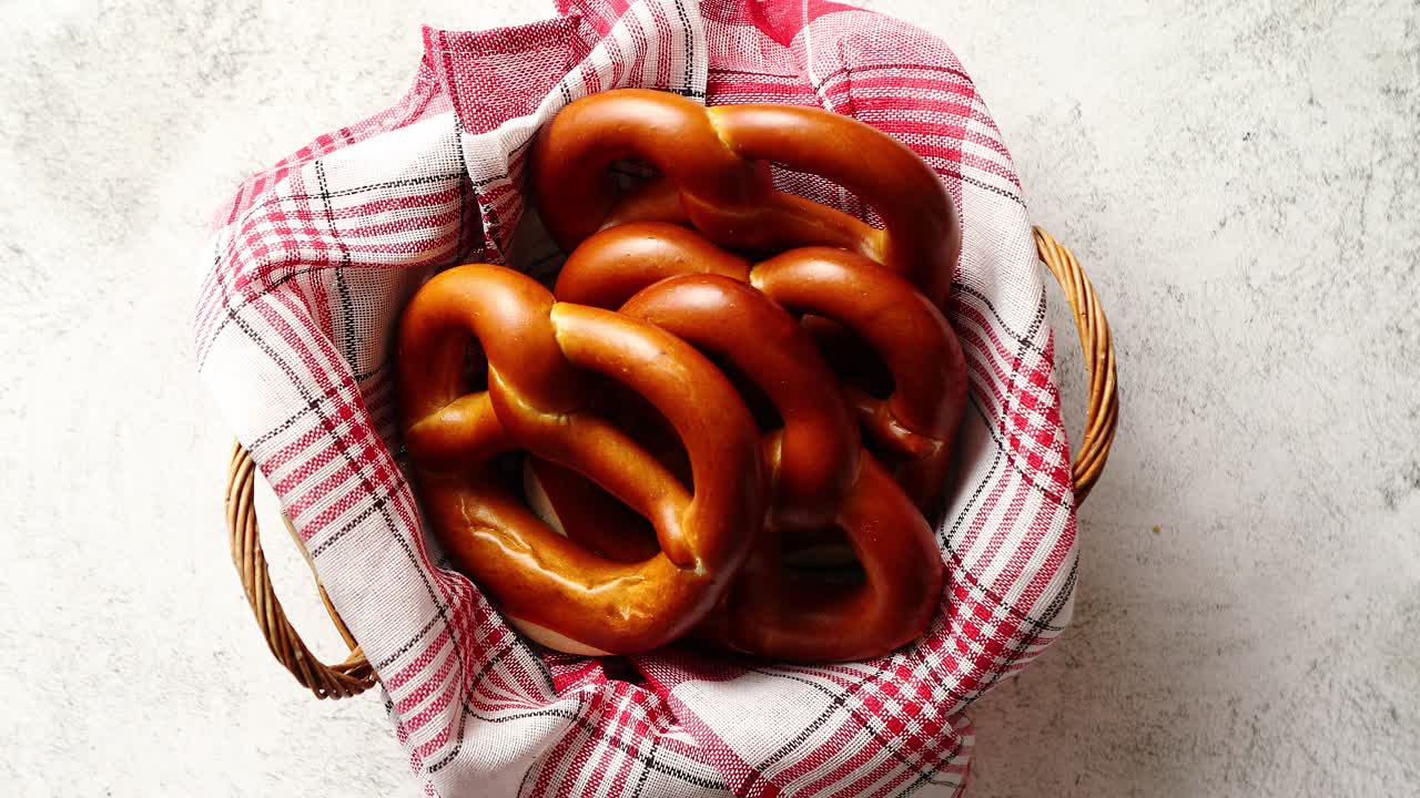 Kori, jossa on punavalkoruudullinen lautasliina ja tuoreita ruskeita rinkeleitä.