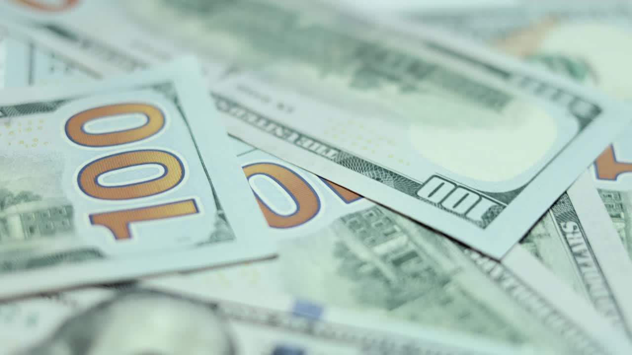 un montón de billetes de cien dólares, en mano de cerca