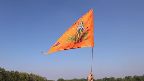 Heilige-Safran-Flagge-Mit-Lord-Rama-Idol-In-Der-Hand-Mit-Strahlend-Blauem-Himmelshintergrund-Am-Tag