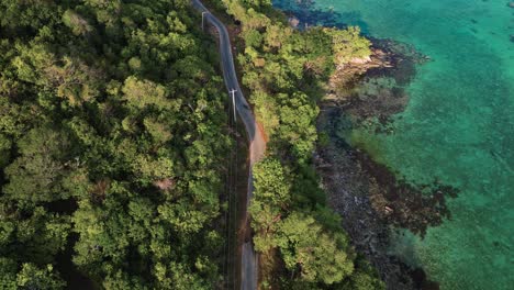 aerial view looking down to a scenic coastal road in karimunjawa island - a beautiful touristic island with white sand beach and turquoise sea water