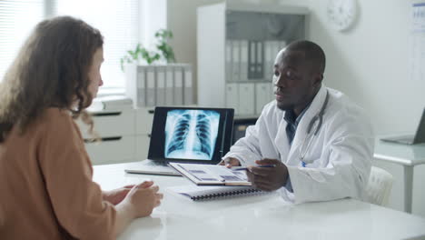 doctor reviewing medical records and providing consultation to woman