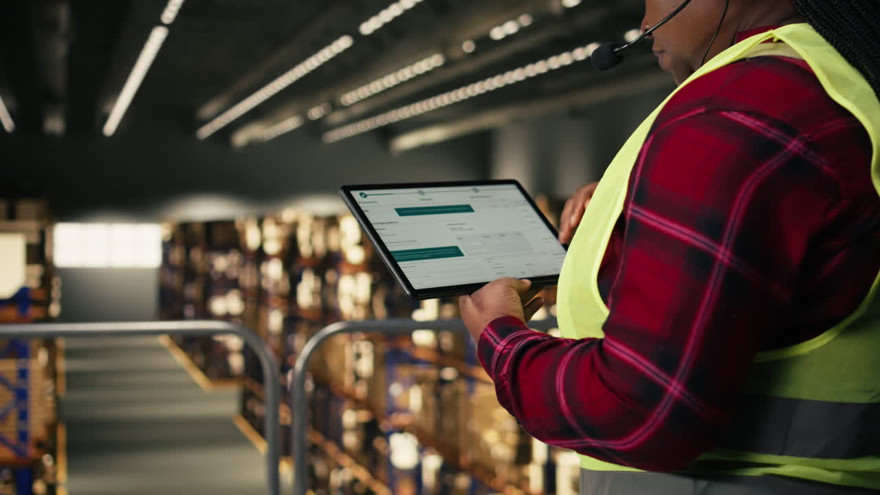 Female Warehouse Worker Using Tablet and Headset for Inventory Management