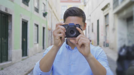 vista frontal de fotógrafo masculino con cámara digital al aire libre.