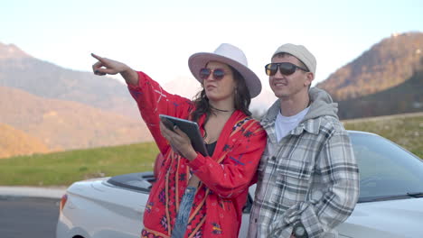 una pareja explorando las montañas en un coche descapotable