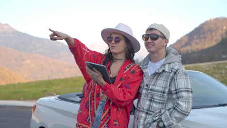 couple exploring mountains in a convertible car