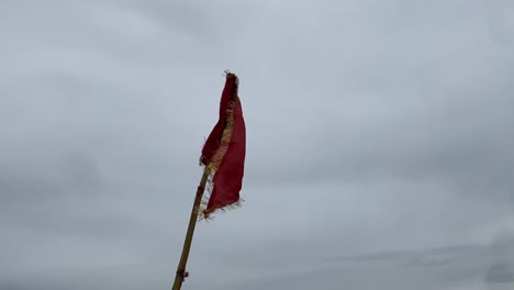 a hindu bajrang bali flag is fluttering in a cloudy sky