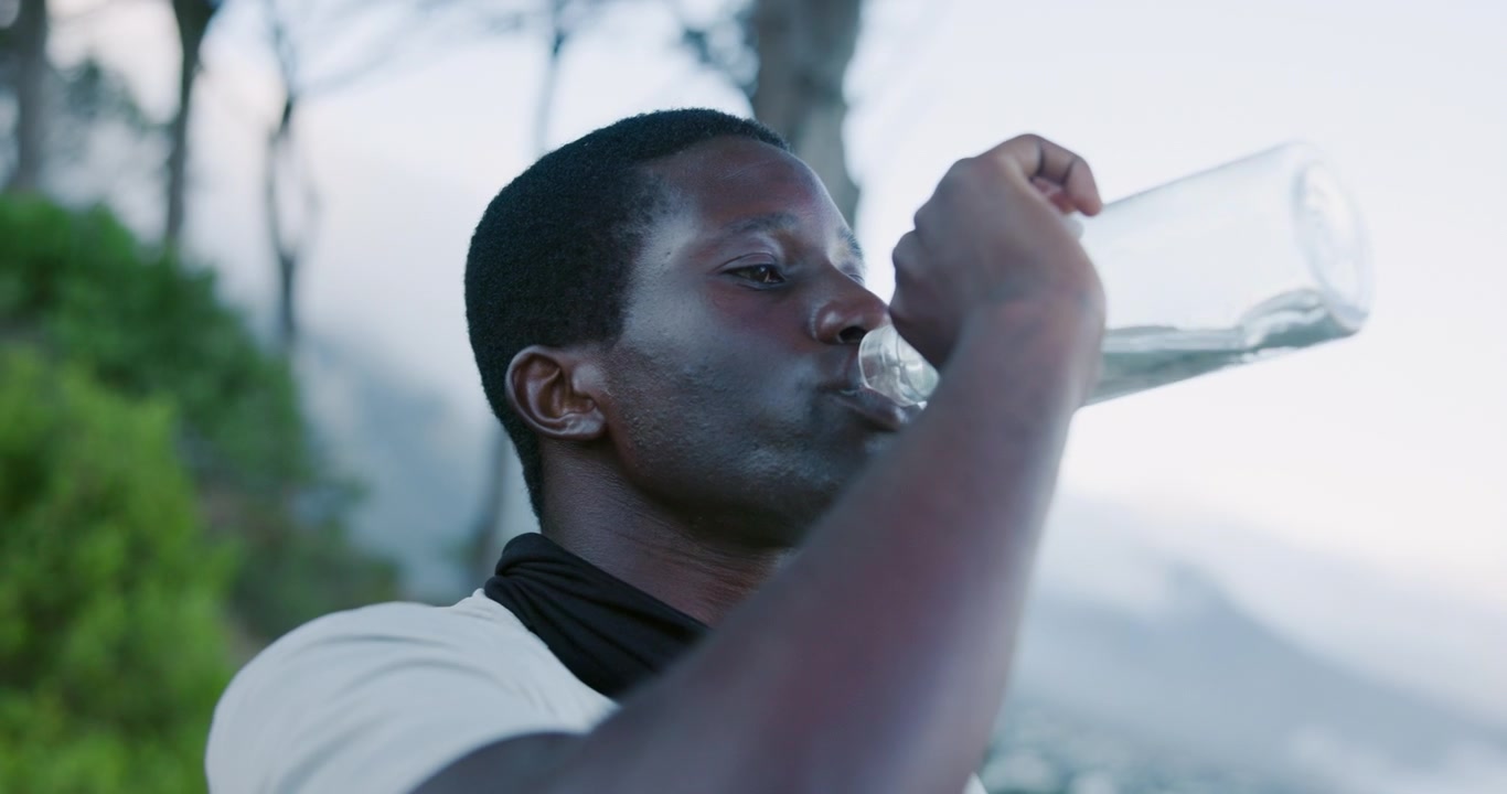 Young Man Drinking Water After Outdoor Exercise