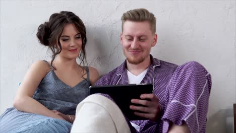 couple relaxing at home with tablet