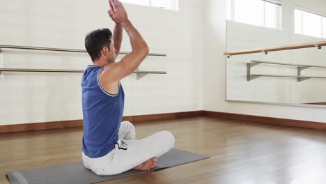 Hombre-Caucásico-Enfocado-Practicando-Meditación-De-Yoga-En-El-Gimnasio,-Cámara-Lenta