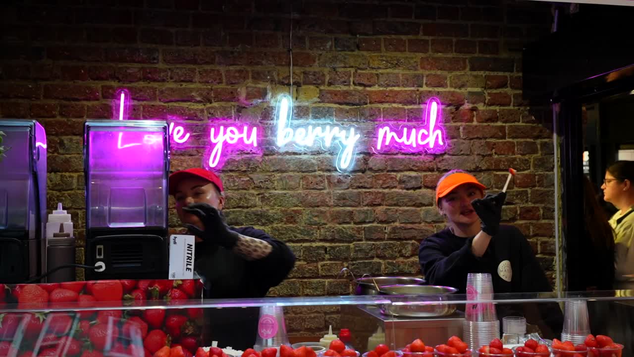 Neon sign reading "Love you berry much" over a strawberry stand in Camden Town, London