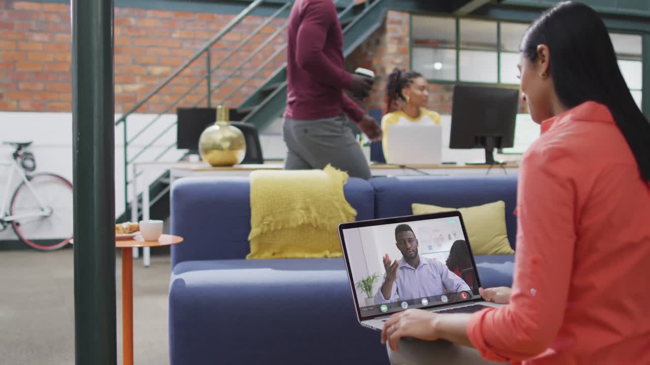 Imprenditrice birazziale che usa il laptop per una videochiamata con una collega d'affari afroamericana