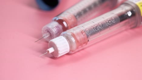 insulin pens on pink background